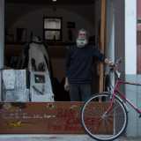 E subito dietro l'uscio, mentre mantiene la sua fedele bicicletta rossa, c'� proprio il barbuto Paolo, il "padrone di casa"